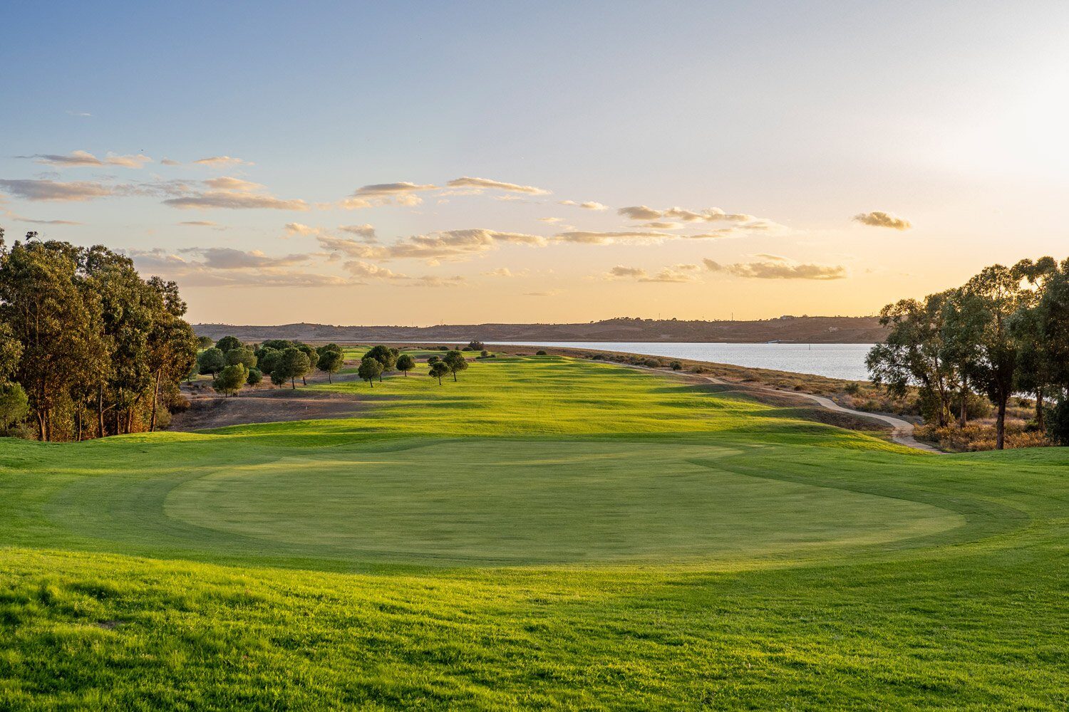 Isla Canela Links fairway at golden hour, sweeping toward the Atlantic